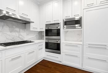 A kitchen with white cabinets and stainless steel appliances